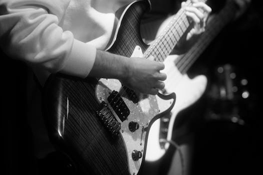 Black and white photo capturing a musician playing an electric guitar at a rock concert in Ankara.