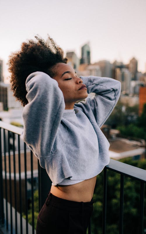 Free Photo of Woman in Gray Sweatshirt and Black Pants Posing With Her Eyes Closed Stock Photo