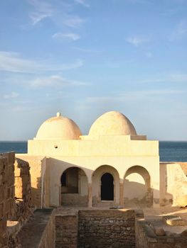 Scenic view of ancient dome architecture overlooking the sea under a clear sky.