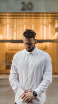 一个穿着清爽白衬衫的男人在户外沉思的肖像