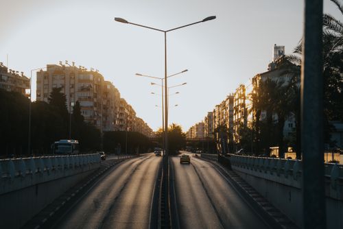 Free Capture of an urban road with high-rise buildings at sunset, offering a serene cityscape view. Stock Photo
