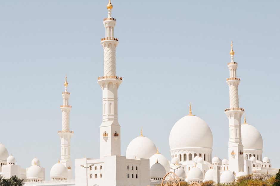 Majestic perspective of Sheikh Zayed Grand Mosque showcasing its domes and minarets under clear skies in Abu Dhabi.