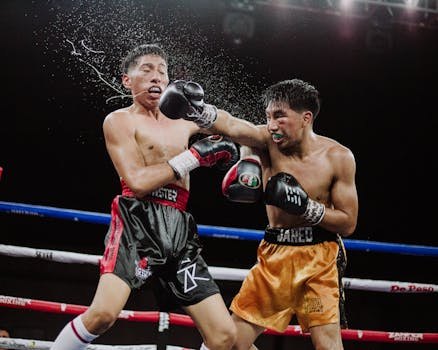 Intense action shot of two boxers in the ring during an energetic boxing match.