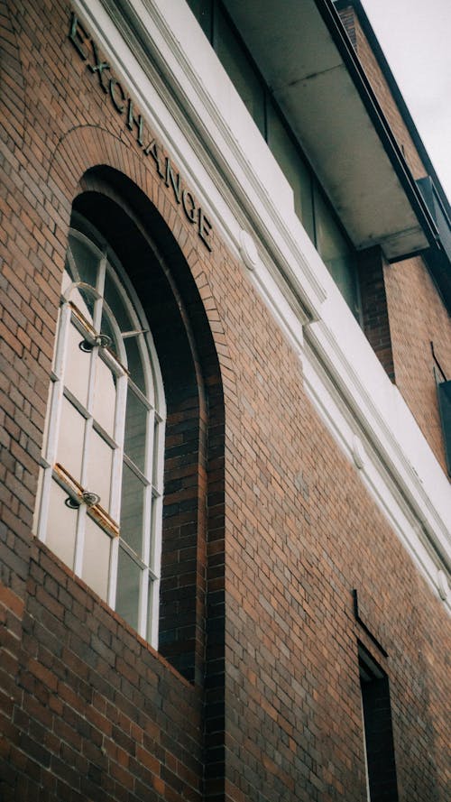 Foto De ángulo Bajo De Edificio De Ladrillo Con Ventana De Vidrio Cerrada