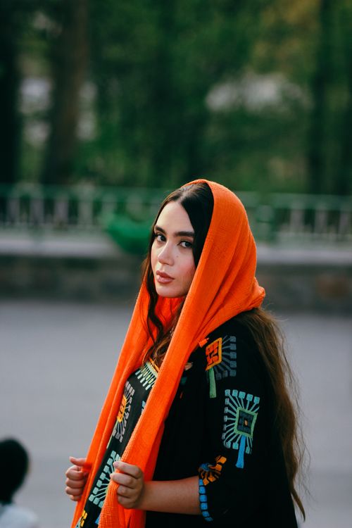 Free Portrait of a young woman in a colorful hijab in an outdoor setting, exuding confidence and style. Stock Photo