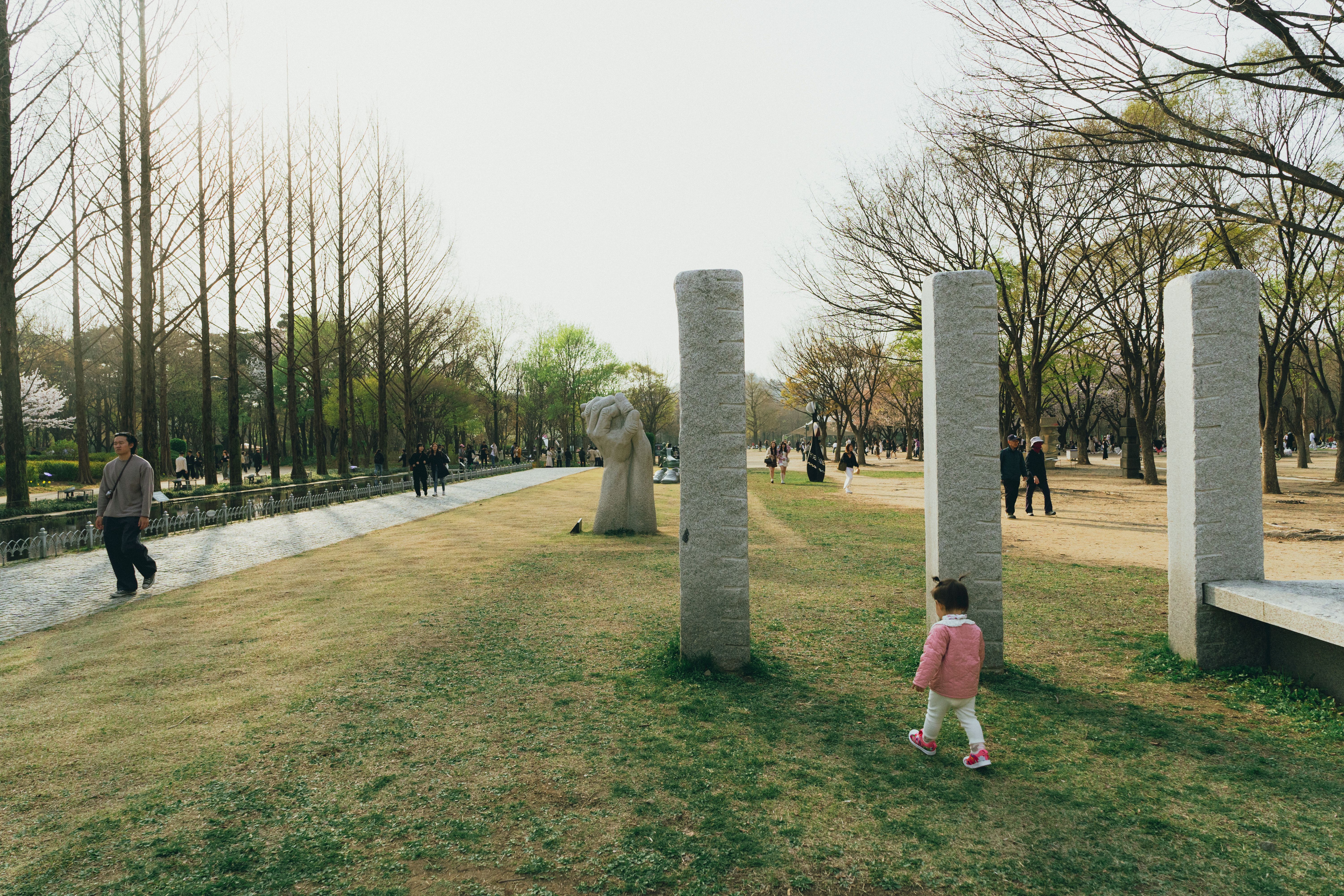 A serene scene in a Seoul park during spring, featuring families enjoying a cheerful afternoon.