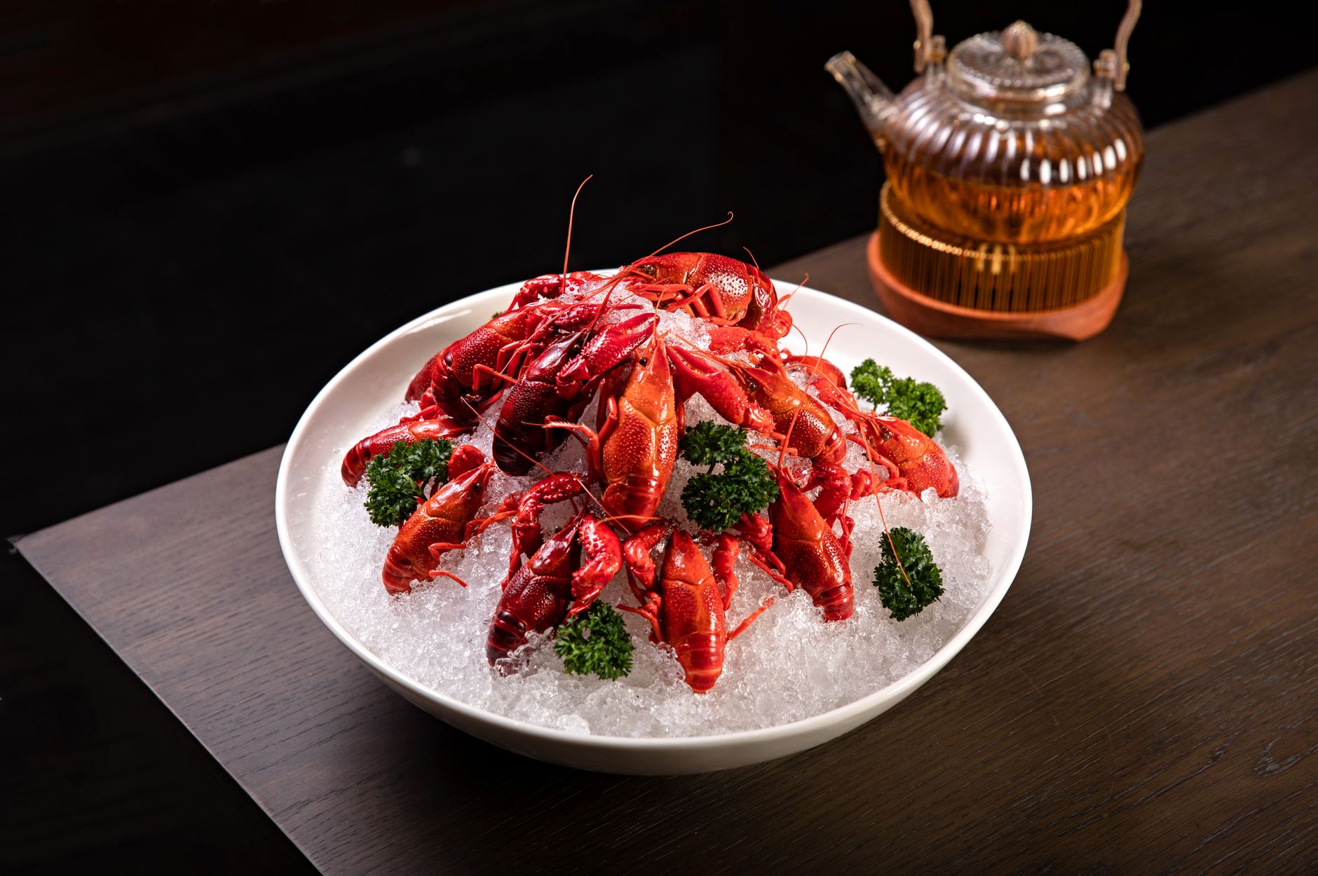Freshly cooked lobsters served on ice with parsley garnish, ideal for seafood enthusiasts.
