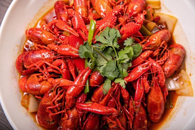 A bowl of spicy cooked crawfish garnished with cilantro