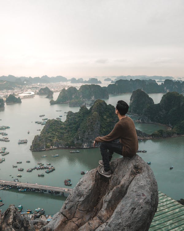 Man Sitting on Rock Overlooking the Famous Ha Long Bay in Vietnam