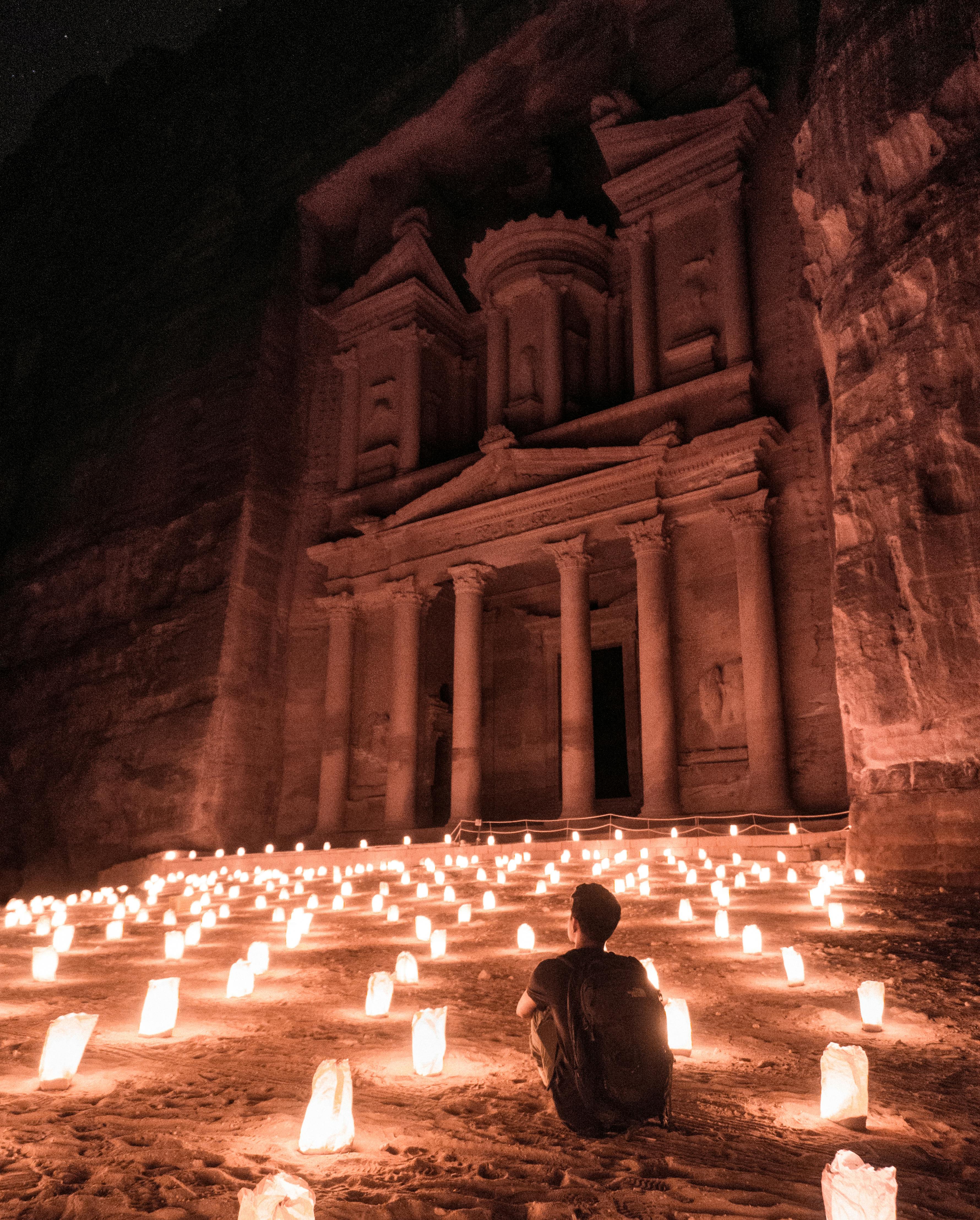 a man sitting outside of the famous petra