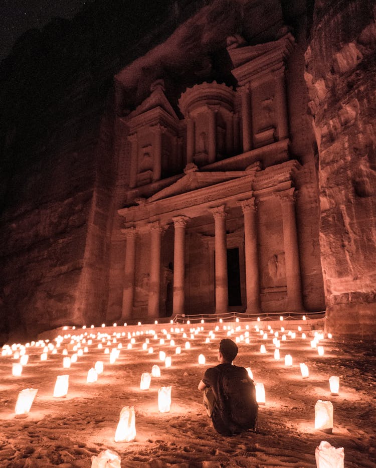 A Man Sitting Outside Of The Famous Petra