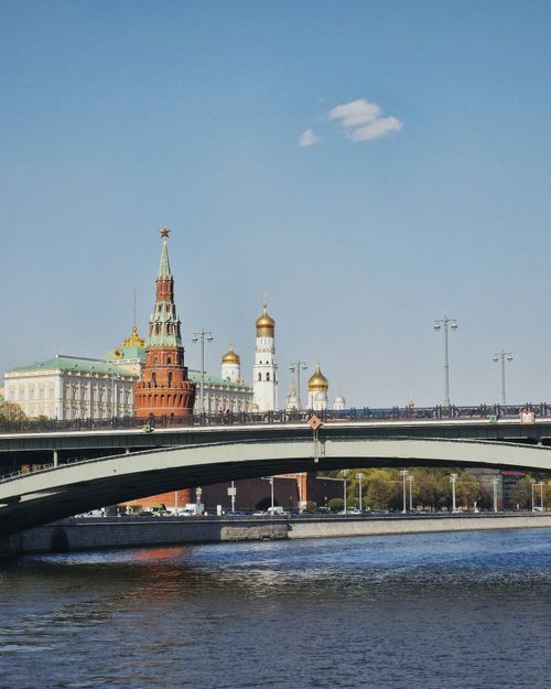 Free Iconic view of the Moscow Kremlin with a bridge over the Moskva River under a clear blue sky. Stock Photo