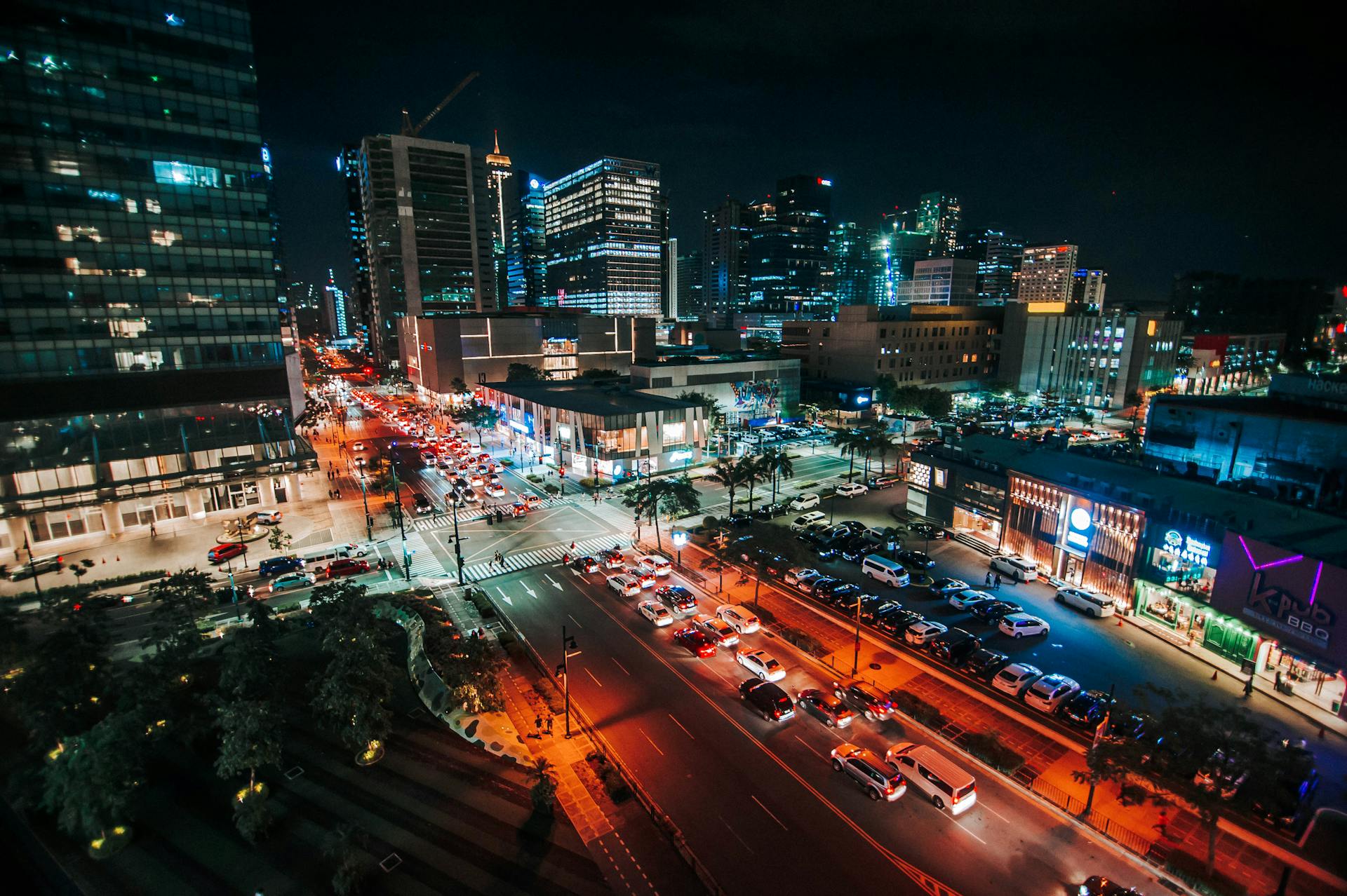 A stunning aerial view of the illuminated cityscape of Taguig City, Philippines at night, showcasing urban life.