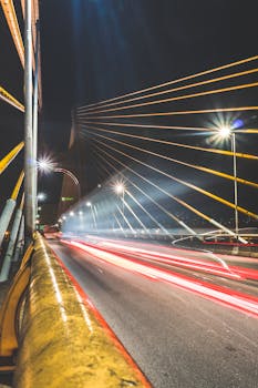 这张长曝光夜景照片中的桥梁，生动展现了流动的光轨