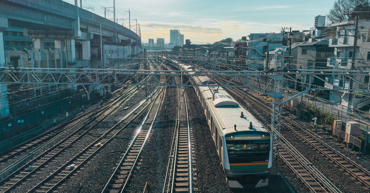 Captivating aerial view of train tracks with a train in Tokyo's Kita Ward, capturing urban life.