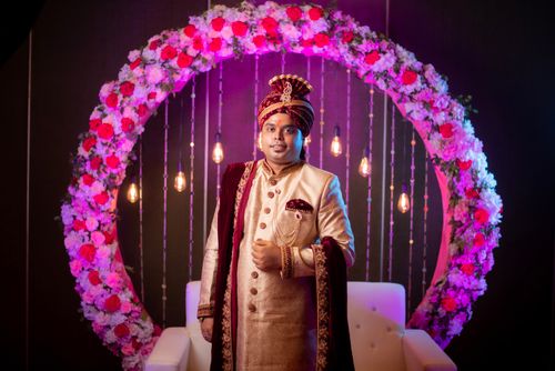 Free Indian groom in traditional attire during wedding ceremony with floral backdrop Stock Photo