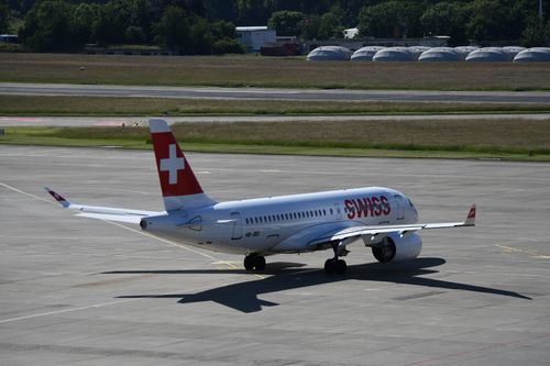 Free A Swiss passenger plane taxiing on the runway at sunny Geneva Airport in Switzerland. Stock Photo