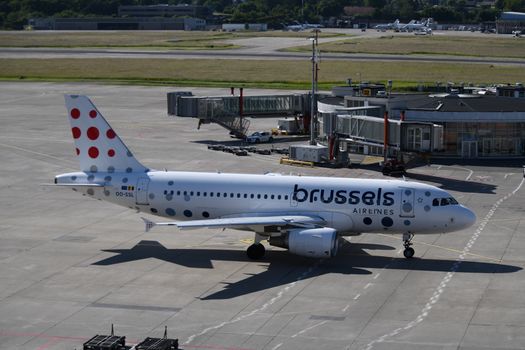 A Brussels Airlines plane taxiing at Geneva Airport, ready for takeoff on a sunny day.
