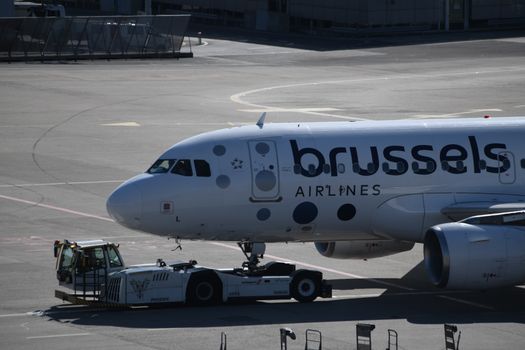 Brussels Airlines plane being towed on the runway at Geneva Airport, ready for takeoff.
