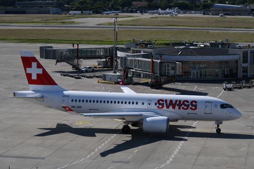 Free A Swiss airplane taxiing at Geneva Airport, showcasing its design and engineering. Stock Photo