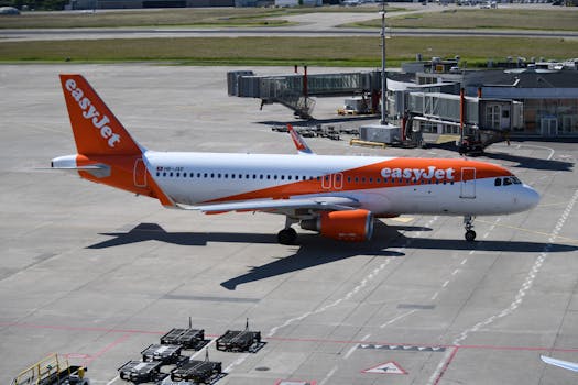 EasyJet Airbus A320 taxiing at Geneva Airport with clear blue skies.