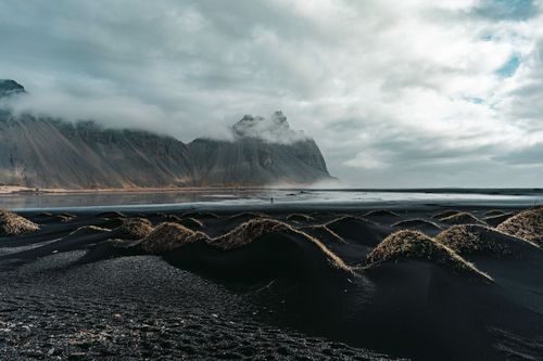 Free Breathtaking view of Stokksnes' black sand dunes and mountains under a cloudy sky in Iceland. Stock Photo