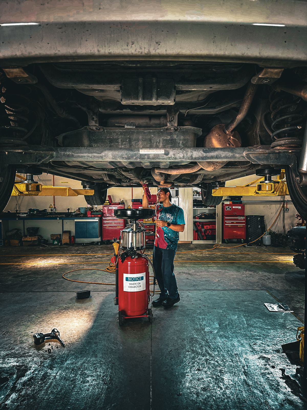 Mechanic working under a car in a repair shop