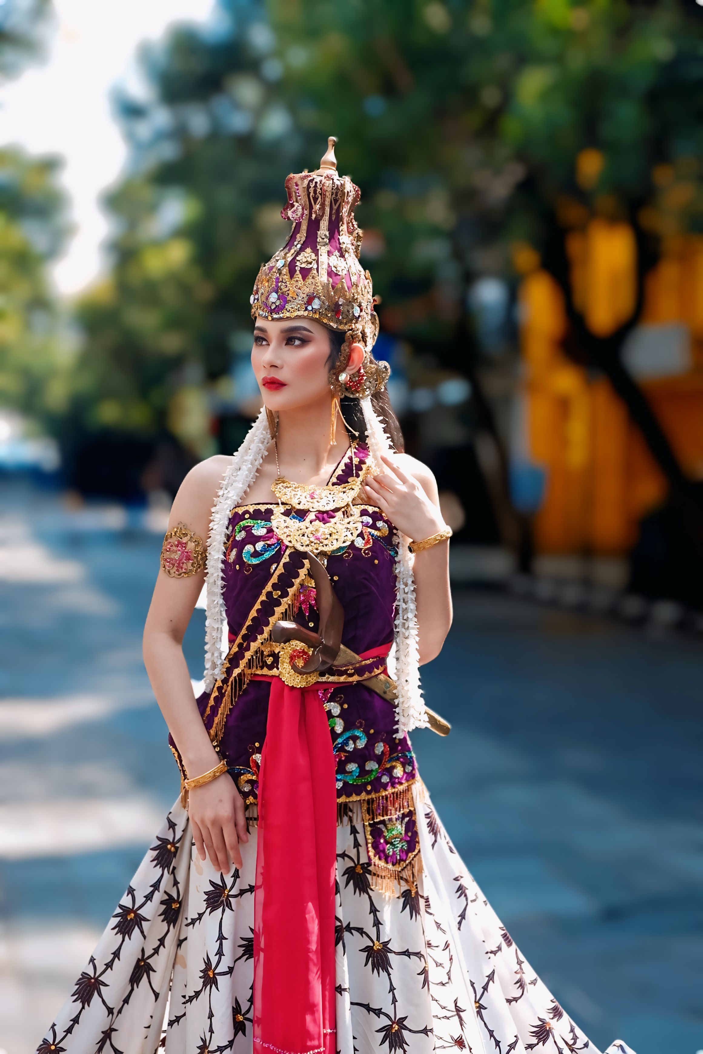 A woman in traditional Javanese attire standing outdoors, showcasing rich cultural heritage.