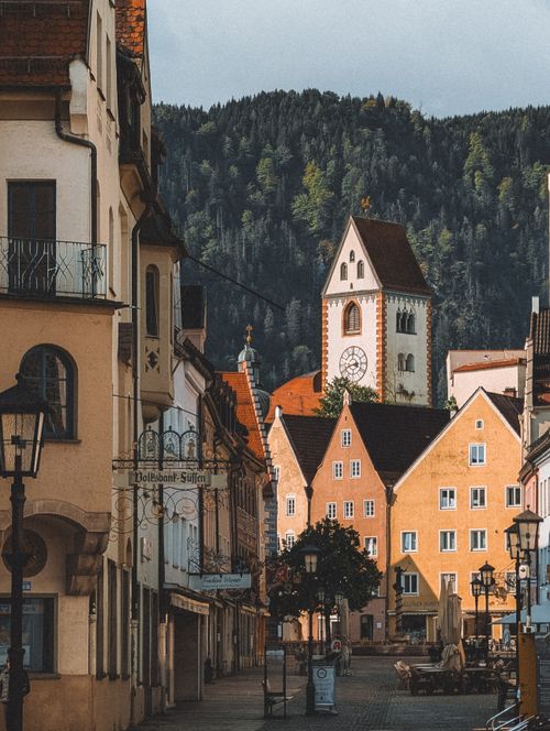 Free Picturesque view of Füssen, Bavaria with St. Mang's Abbey tower surrounded by quaint buildings. Stock Photo