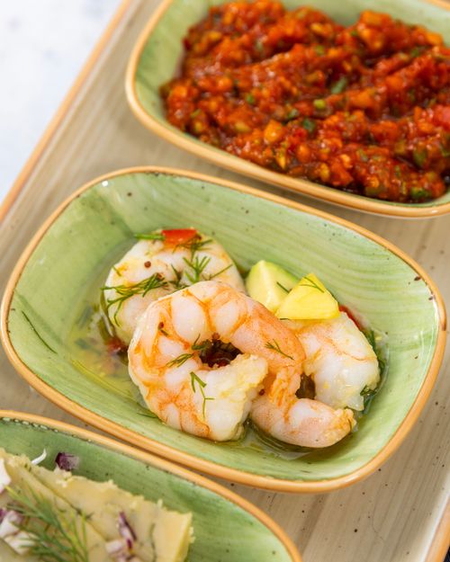 Free Delicious shrimp with herbs, red sauce, and cheese appetizers served elegantly. Stock Photo