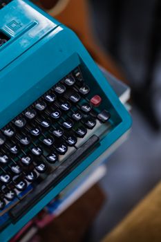 Close-up view of a vintage blue typewriter, emphasizing its keys and classic design.