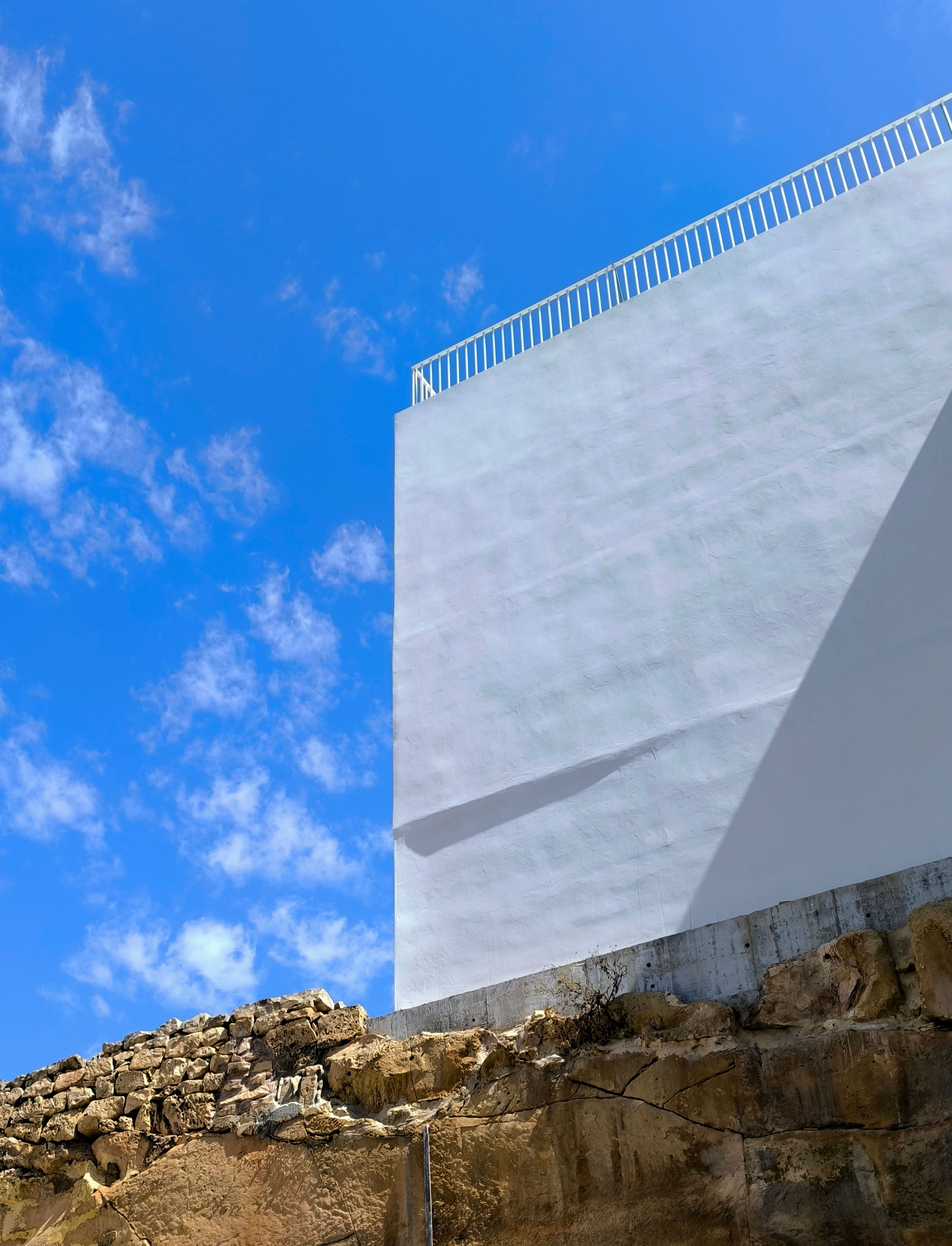 Modern Architecture Meets Natural Stone Below Blue Sky · Free Stock Photo