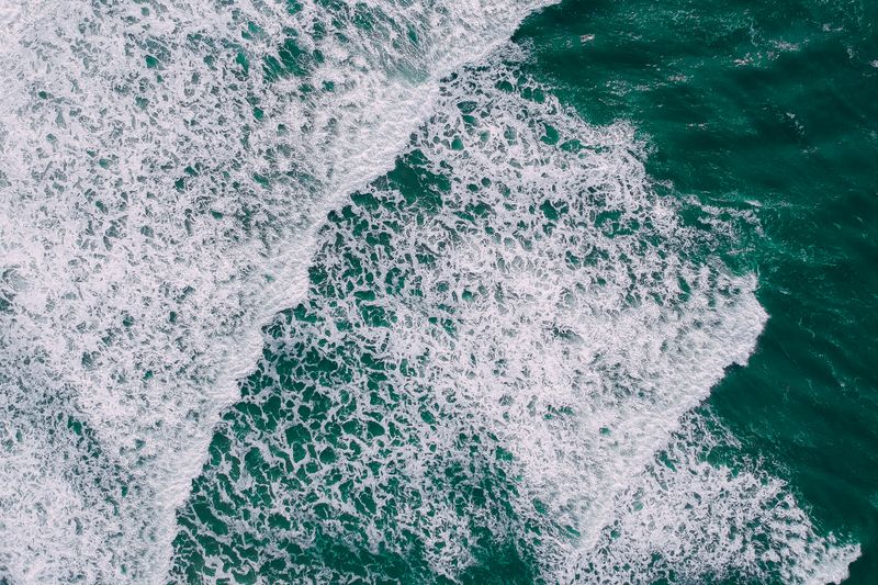 Aerial view of breaking surf and foam patterns — photo by Pok Rie from Pexels