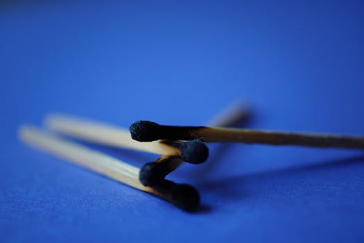 蓝色表面上烧焦木制火柴棍的宏观特写镜头