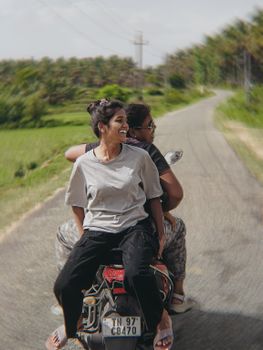 Two friends enjoy a motorcycle ride on an open road, embracing freedom.