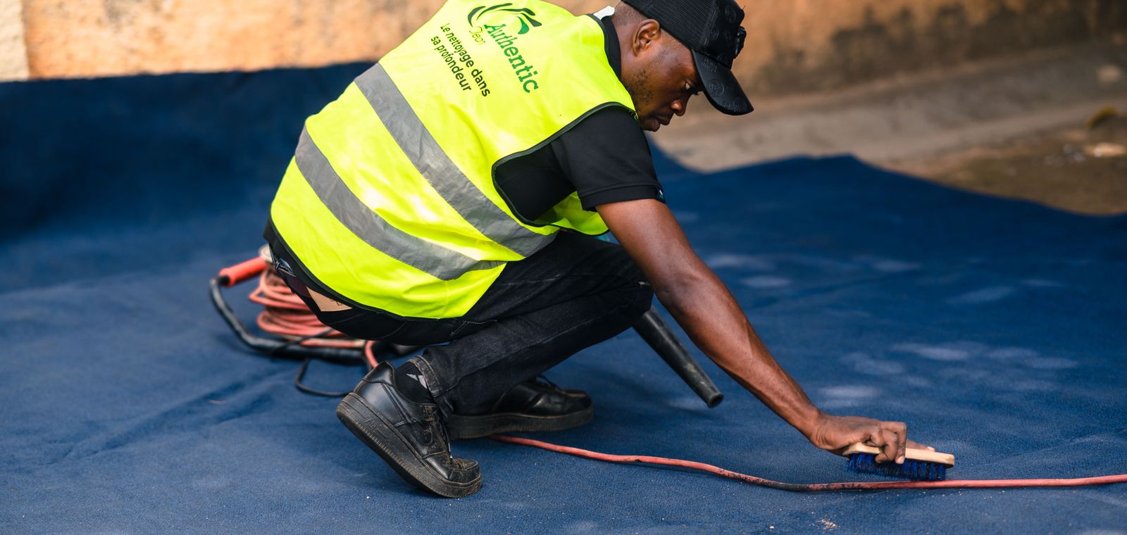 Worker brushing and cleaning a carpet