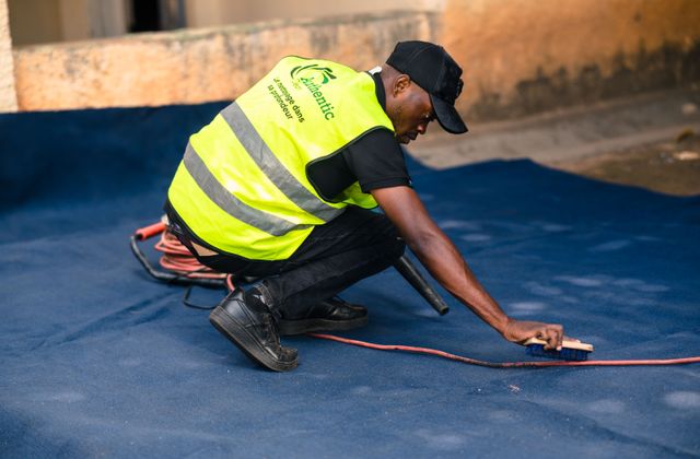 Worker brushing and cleaning a carpet