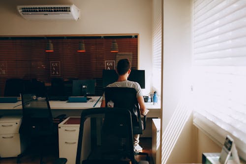 Kostenlos Person Im Grauen Hemd, Das Auf Computerstuhl Sitzt Stock-Foto