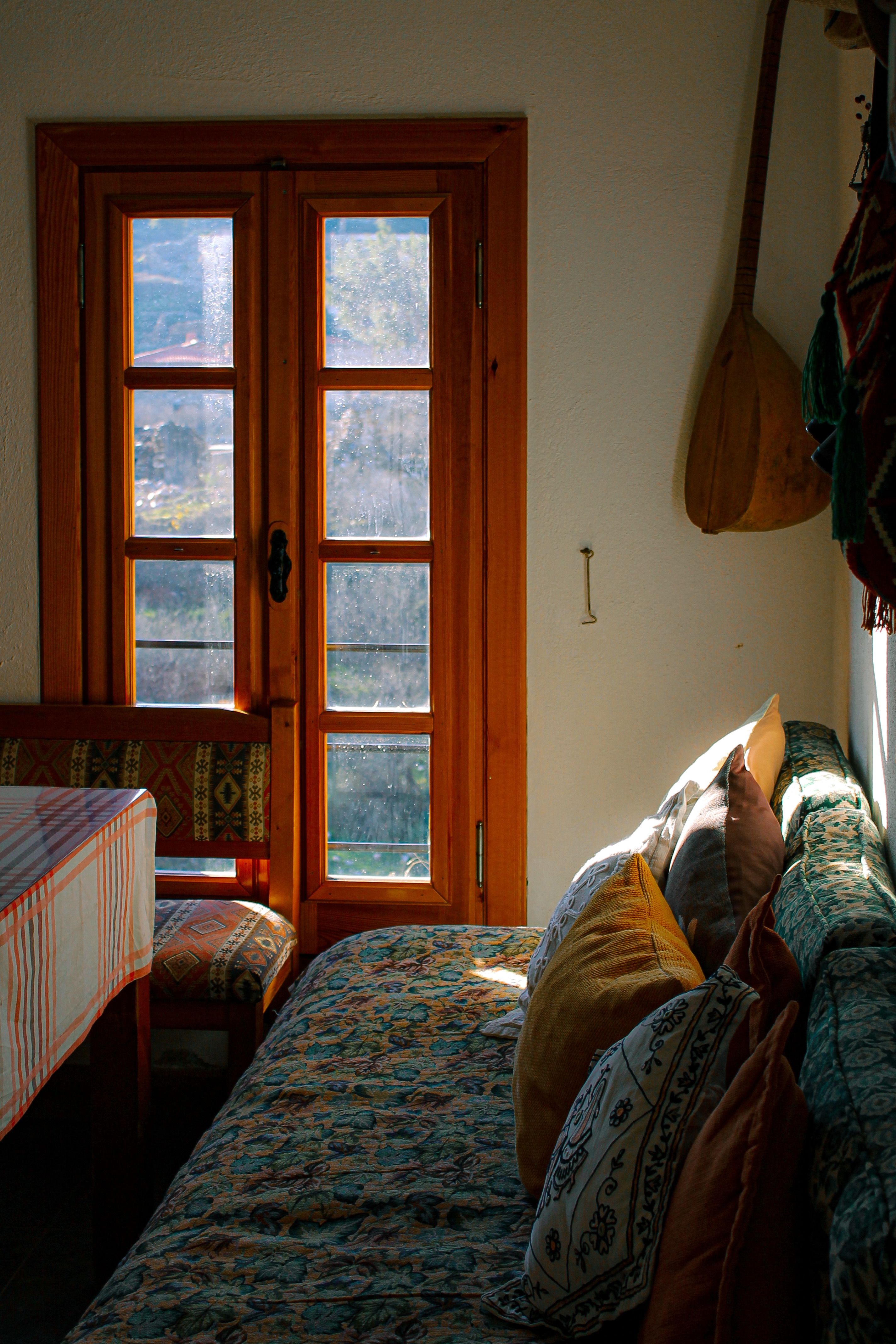 Warm and inviting room with sunlight streaming through a wooden window, creating a cozy, rustic atmosphere.