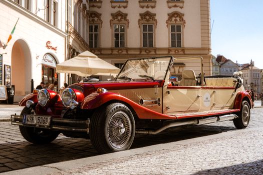 A classic vintage car parked on a historic street in Prague, Czechia.