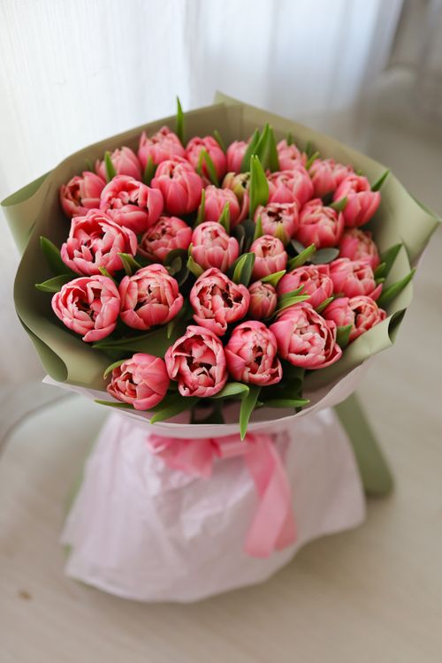 Free A beautiful bouquet of pink tulips wrapped in paper, capturing the essence of spring. Stock Photo
