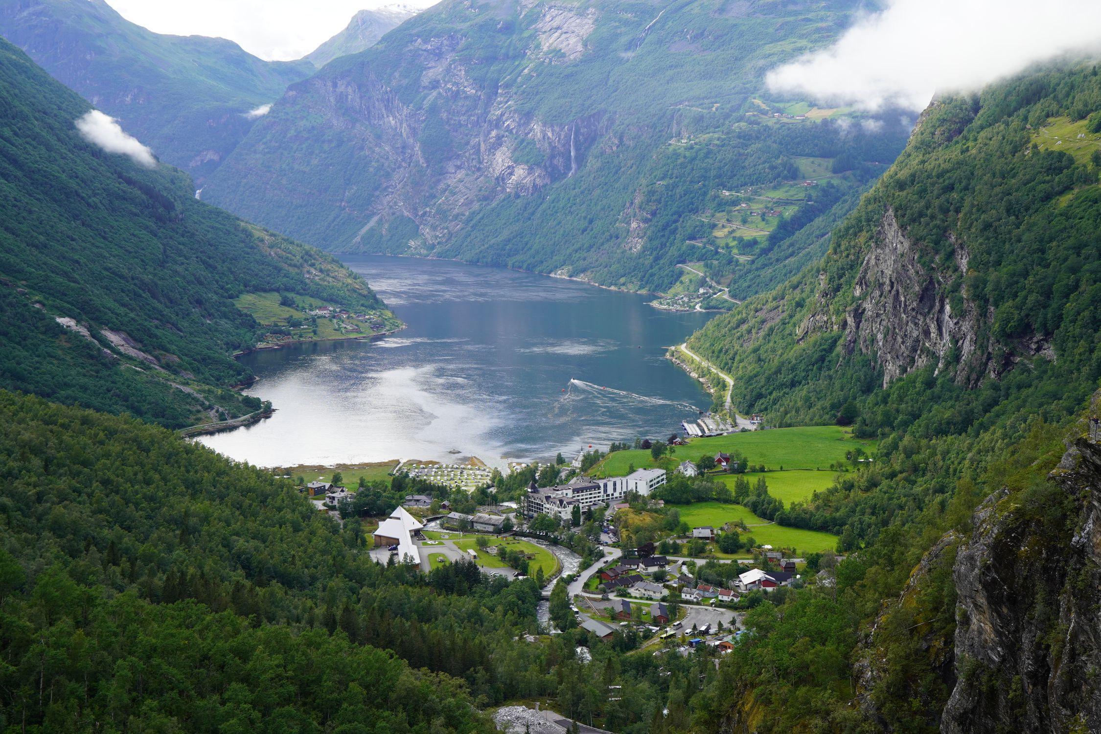 Scenic aerial view of Geiranger Fjord with lush greenery and calm waters in Norway.