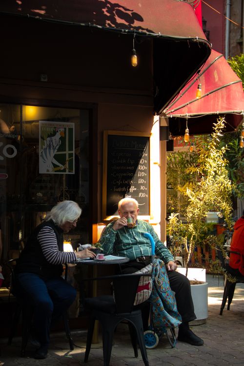 Free An elderly couple relaxes at a quaint Istanbul café, enjoying a warm afternoon. Stock Photo