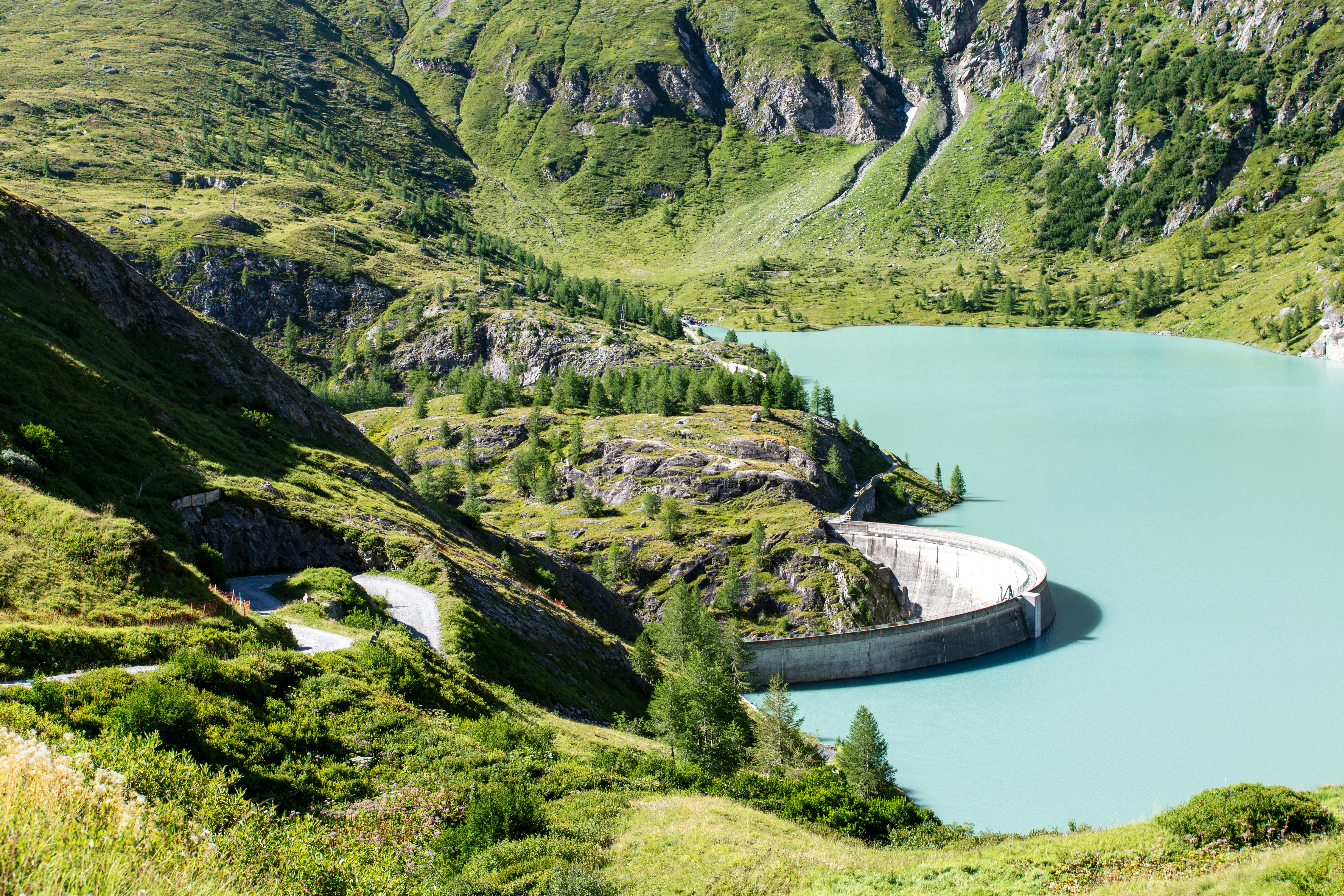 Scenic view of an alpine reservoir surrounded by lush green mountains in Korutany, Austria.