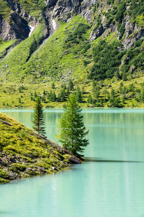 Free Turquoise alpine lake surrounded by green mountains in Korutany, Austria. Stock Photo