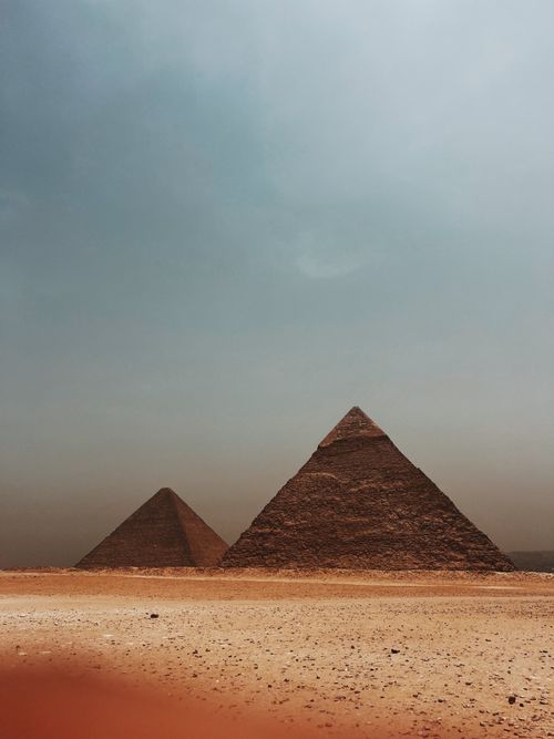 Free Stunning view of the iconic pyramids in Giza under a striking blue sky. Stock Photo