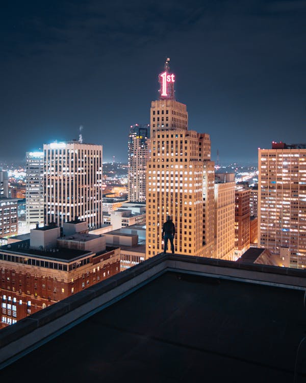 Free Person Standing at the edge of Building at Night Stock Photo
