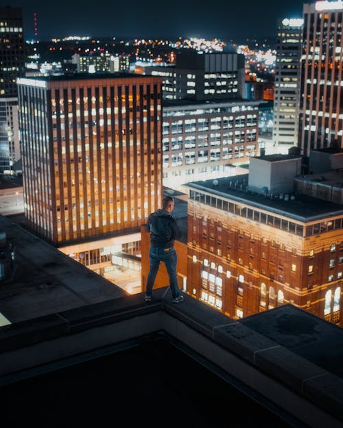 Free Man in Black Jacket Standing on Edge of Building Stock Photo