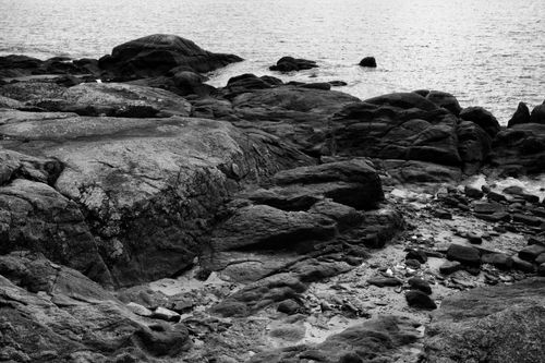 Free Monochrome landscape of rugged coastal rocks by the sea. Stock Photo