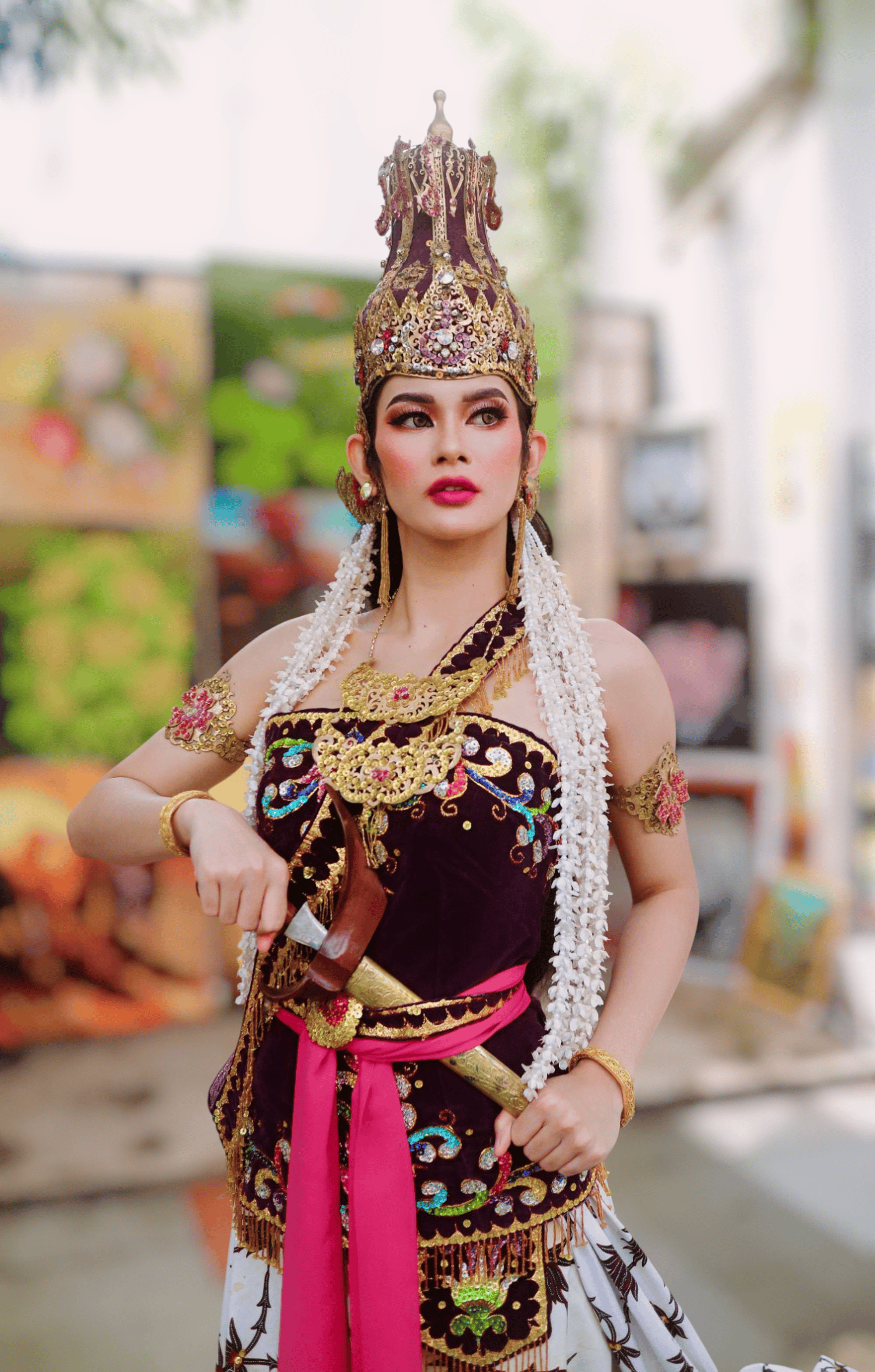 Beautiful Balinese dancer in vibrant traditional attire performing outdoors, exuding cultural elegance.